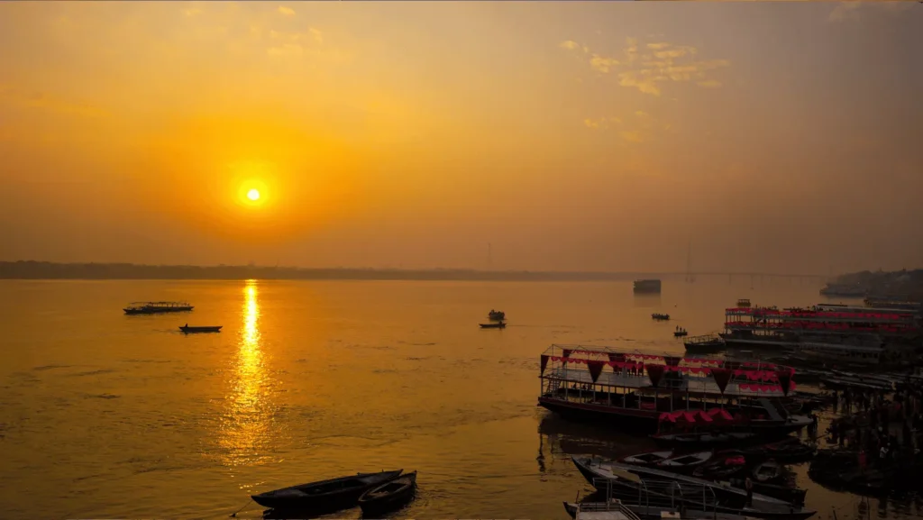 "Sunrise boat ride on the River Ganges Varanasi with ancient ghats in background"